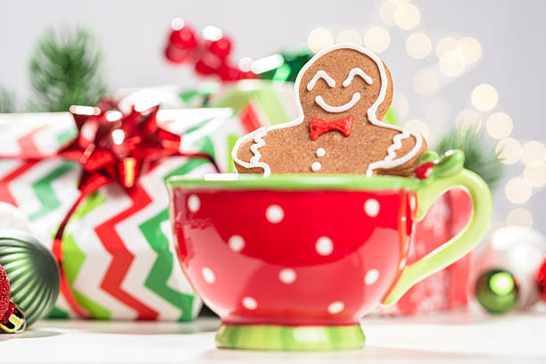 A red cup with a green and white polka dot pattern. A gingerbread man is sitting in the cup