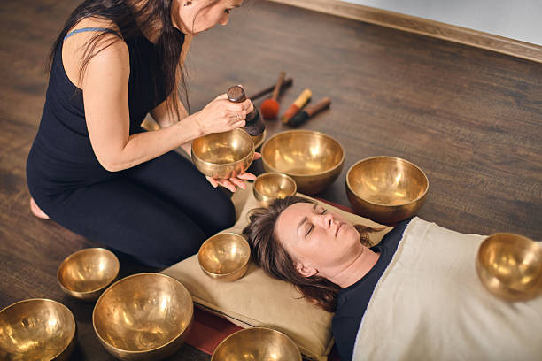 istock Young woman using singing bowls in healing session 2238119533