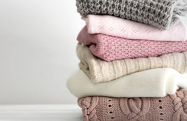 istock Stack of knitted folded clothing, winter autumn stacked woolen clothes. Sweaters folded on table empty copy space. 2238119848
