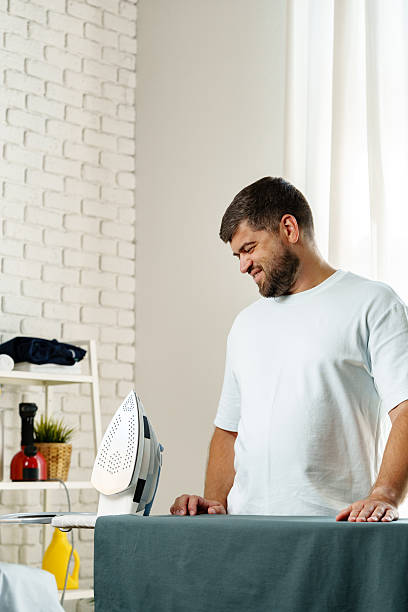 istock Man ironing clothes in a bright and modern laundry room during the day 2238122998