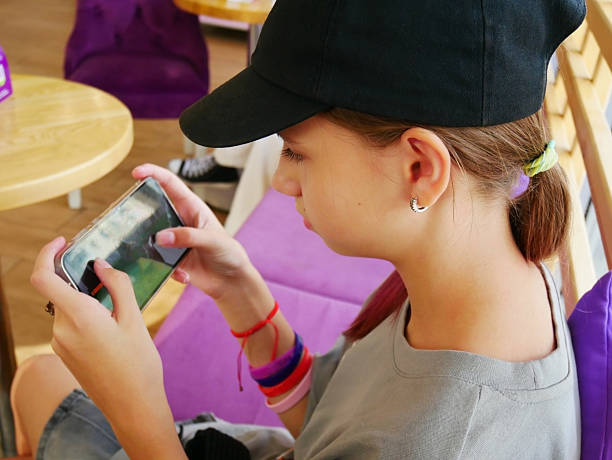 Teen Girl Using Smartphone in Cafe