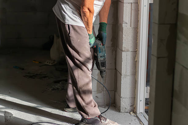 istock Closeup of worker hand with pneumatic hammer drill perforator while drilling wall  for electric cable. 2238125717