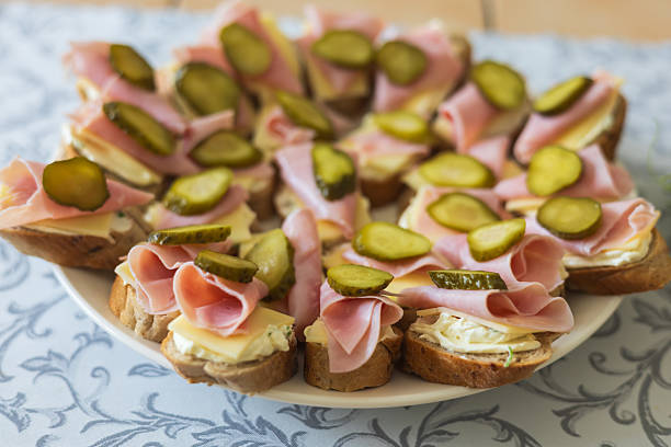 Canapes on a plate as a snack. Salam, cheese, spread and vegetables on a roll