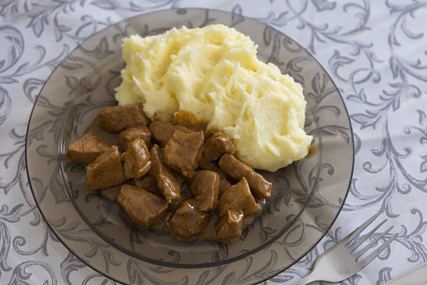 Mashed potatoes and meat cubes with sauce on a plate. Tasty lunch. Flat lay