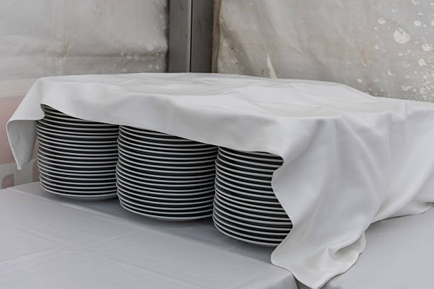 White plates laid out on a table for refreshments are covered with a tablecloth