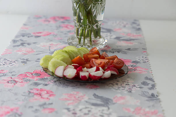 Fresh Tomato, Cucumber, and Radish Salad in a White Bowl on Green Background.