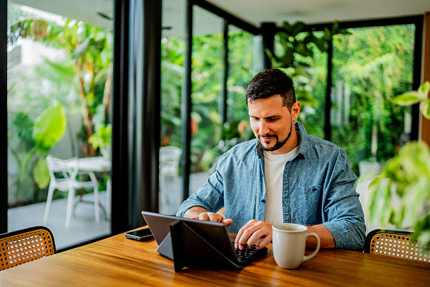 istock Australian mid adult man using digital tablet at home 2238129763