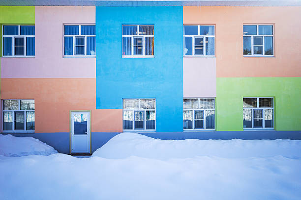 a two-storey administrative building painted in different colors against a background of snowdrifts