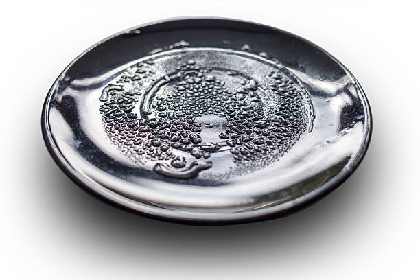 Wet black plate, covered with water drops. isolated on white