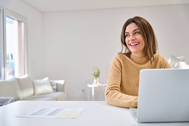 istock Happy mature woman using laptop at home table looking away at copy space. 2238131479