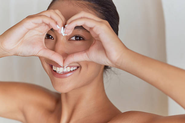 istock Smiling Woman Framing Eyes with Hands in Heart Shape Gesture 2238134613