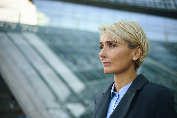 istock Caucasian Middle Aged Woman Standing Outdoors Looking into Distance 2238134987