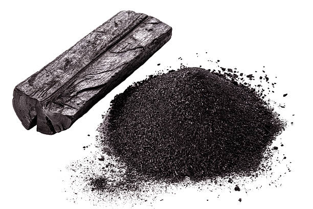 pile of coal dust isolated with piece of charcoal on white background