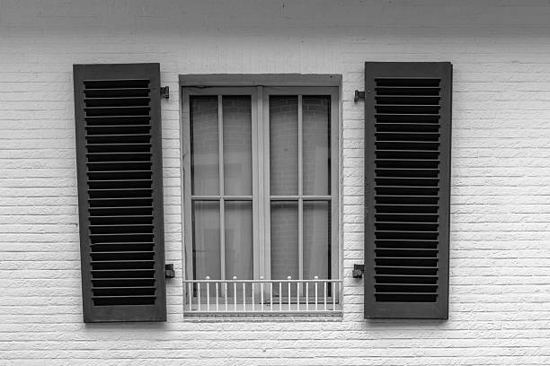 Architectural detail from an old abandoned and partly ruined house in Greece. The image was captured on black and white grainy ISO 400 film by an analogue film camera and a short telephoto prime lens. The granularity is real film grain (due to the presence of small particles of a metallic silver on the negative). The negative was captured by a a digitizer kit connected to a 60mm f/2.8 macro lens and a full-frame DSLR camera, and converted to a positive by software. Minimal post processing has been done (only adjustment of histogram). The image is part of a series of abandoned and partly ruined houses.