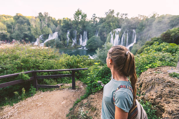 istock Woman Enjoying Scenic Waterfall Nature View 2238139076