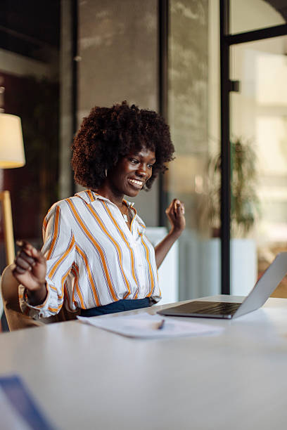 istock Young Professional Celebrating Achievement While Working at a Modern Office Desk 2238139234