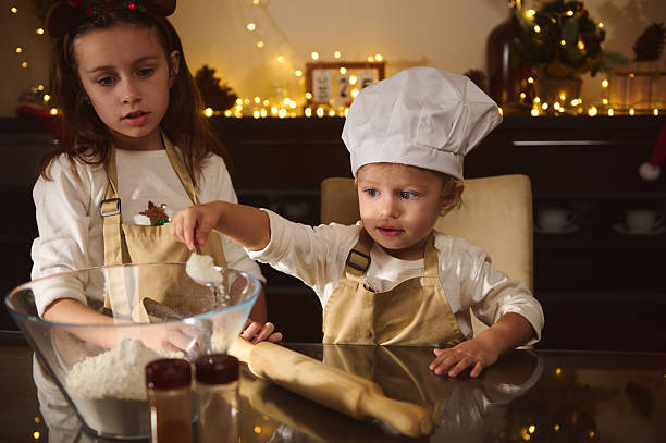 istock Two Kids Baking Gingerbread With Chef Hat In Cozy Christmas Kitchen 2238141861