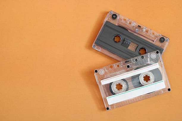 istock Two clear cassette tapes lying on orange background 2238142819