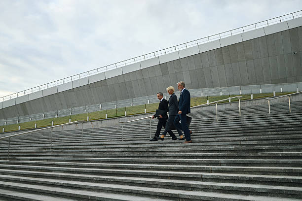 istock Three Middle Aged Caucasian Professionals Walking down Outdoor Steps 2238143428