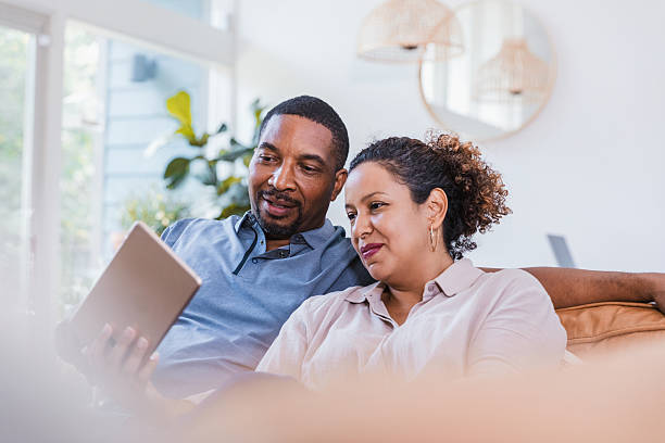 istock Couple relaxing on the couch, using a digital tablet together, sharing a moment. 2238143559