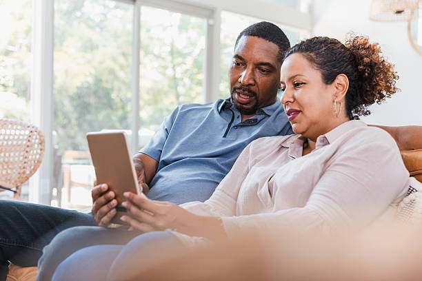 istock Couple relaxes on couch, engaged with tablet, sharing digital content together 2238143574
