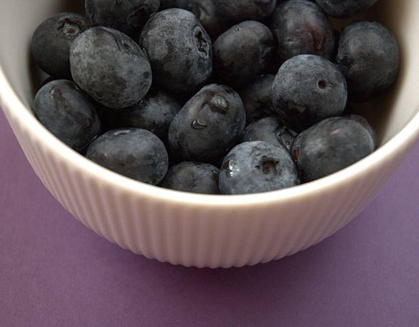 Half and whole blueberries isolated on white background