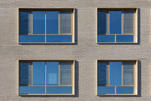 istock Modern facade with square windows. Exterior of a gray building with four windows, safety bars on the windows, minimal design. 2238148530