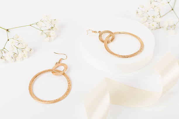 istock Golden earrings with decor on color background 2238151082
