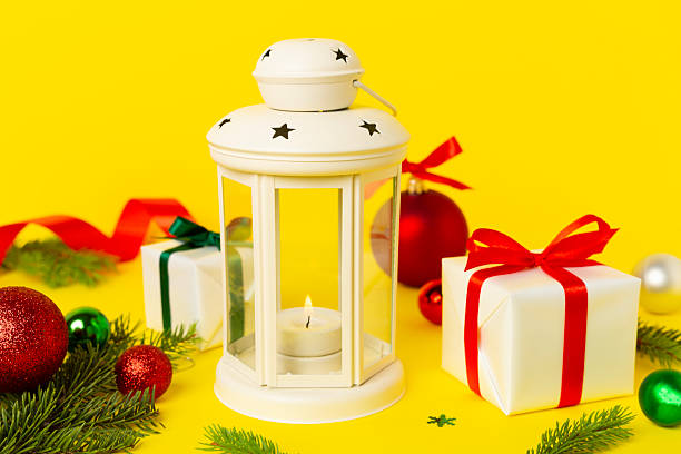 Beige christmas lantern with decorations on color background