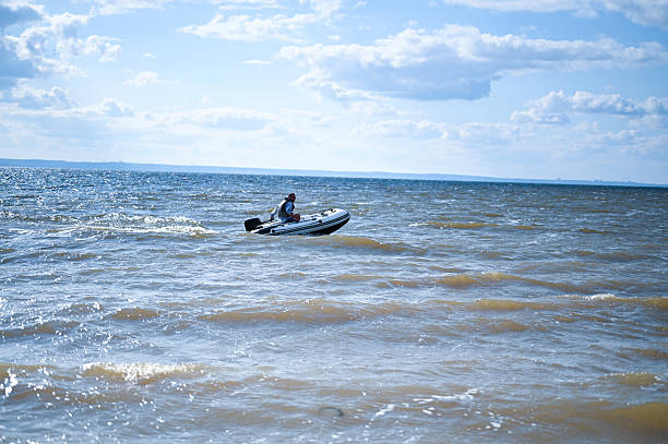 istock Man boating in inflatable motorboat on windy lake 2238154272