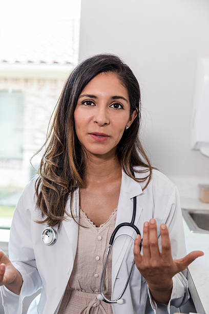 istock Woman doctor with stethoscope explaining something with expressive hand gestures in a bright medical office. 2238154331