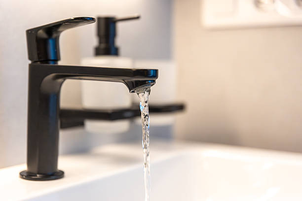 Black faucet water. Minimal sink. Modern bathroom