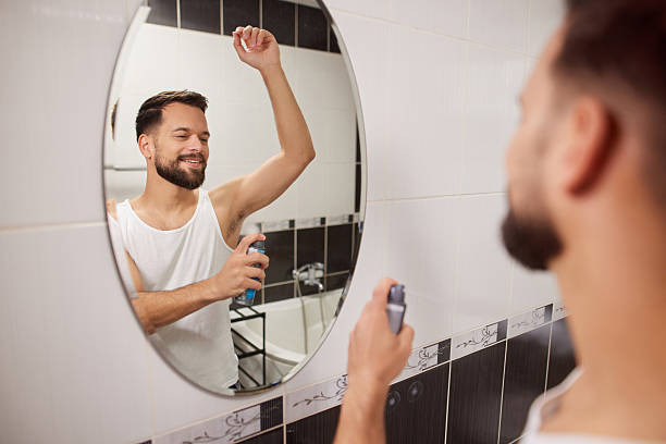 istock Man applying antiperspirant in bathroom mirror during morning routine 2238170870