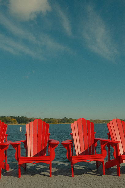 istock Bright Red Adirondack Chairs by the Lake 2238172411