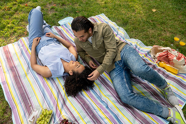 istock Interracial couple relaxing on picnic blanket in park 2238173443