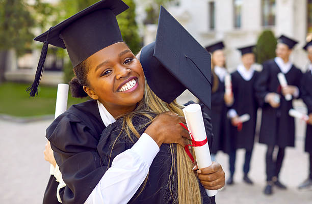 istock Two happy female students hugging during graduation ceremony at college or university. 2238176406