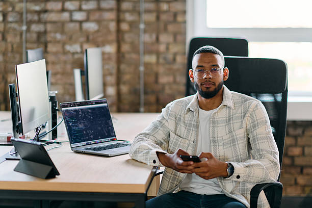 istock African American entrepreneur takes a break in a modern office, using a smartphone to browse social media, capturing a moment of digital connectivity and relaxation amidst his business endeavors. 2238176414