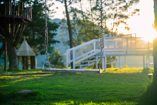 A Japanese female traveller is enjoying swinging on a hand made top swing in a back yard of a house in Ankara.