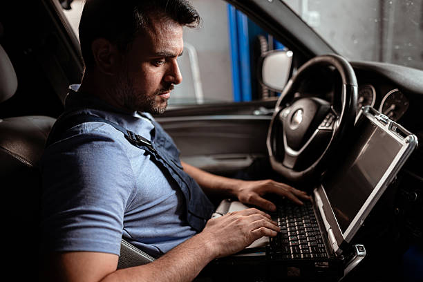 istock Technician performing diagnostics on a car using a laptop in an auto repair shop 2238181997