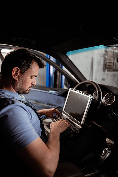 istock Technician uses laptop for car diagnostics in workshop during the day 2238182195