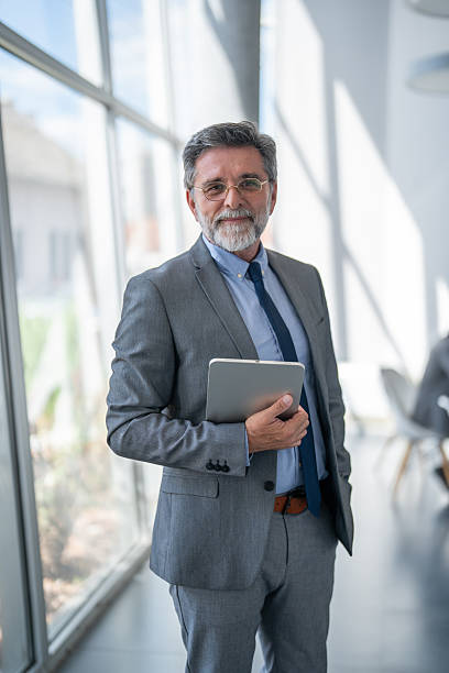 istock Senior businessman holding digital tablet and looking at camera 2238187758