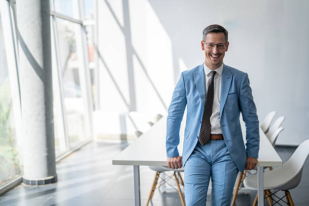 istock Confident businessman smiling at the camera in a modern office 2238187768