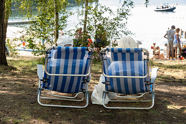 Stockholm, Sweden July 24, 2025 An older couple sitting in beach chairs at a pubic  beach on the Lidingo island on the Baltic Sea.