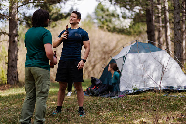 istock Friends enjoying a relaxing camping trip in the woods while sharing stories and drinks around a cozy tent 2238188156