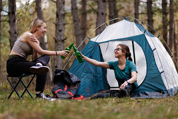 istock Friends enjoying a campsite gathering while toasting with drinks in a serene forest setting 2238188176
