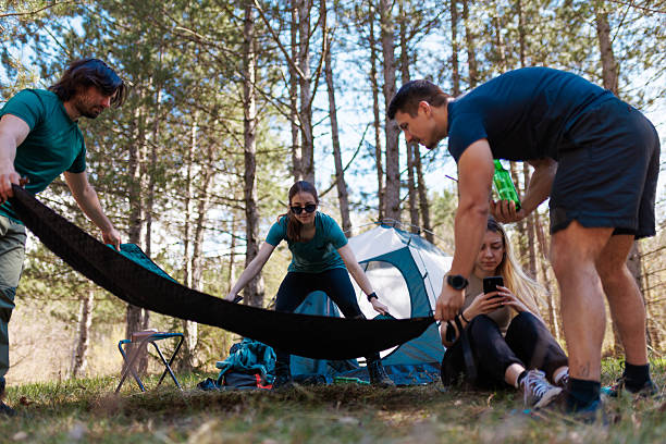 istock Friends setting up a campsite in the forest on a sunny day while preparing for a fun weekend outdoors 2238188180