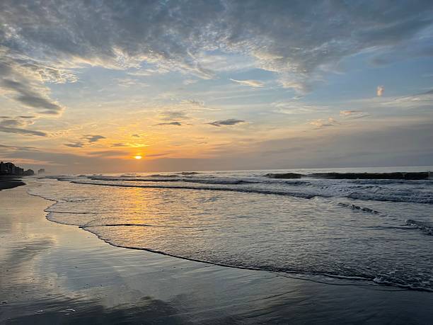 istock Ocean sunrise with clouds parting to reveal warm morning light. 2238189921