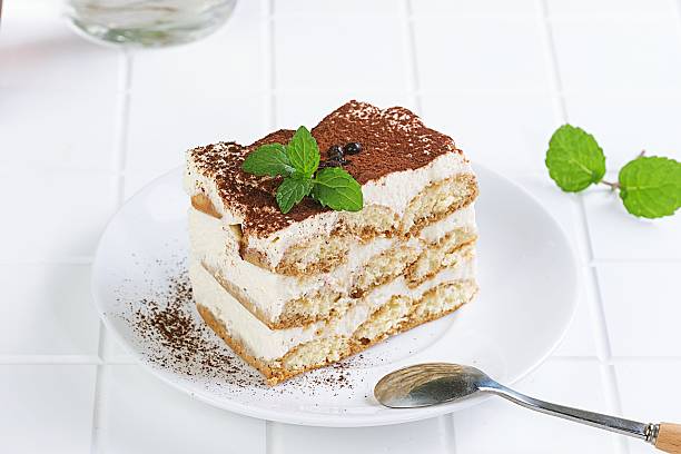 Tiramisu Cake Slice with Mint Garnish and Spoon