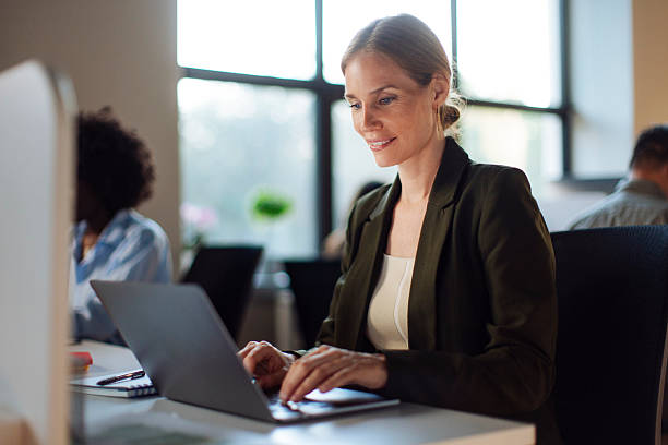 istock Confident Businesswoman Working on Laptop in Modern Office Setting 2238199421