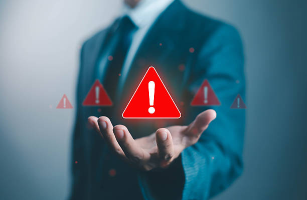 istock Businessman holding glowing red warning signs with exclamation icons, representing risk management, danger, cybersecurity threats, caution, safety, and digital security awareness concepts. 2238201116